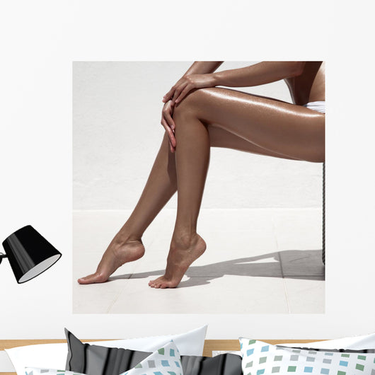Beautiful woman tan legs. Against white wall. Wall Mural