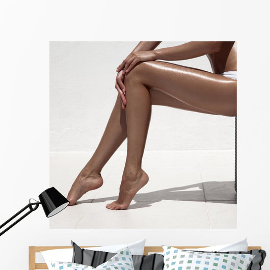 Beautiful woman tan legs. Against white wall. Wall Mural
