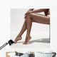 Beautiful woman tan legs. Against white wall. Wall Mural