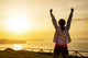 Successful sporty woman with arms up Wall Mural