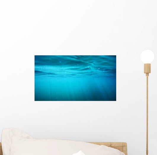 Underwater view with sun beams in turquoise water Wall Mural