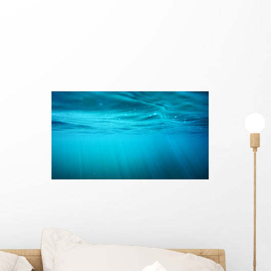 Underwater view with sun beams in turquoise water Wall Mural