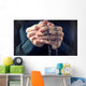 Hands of an elder woman holding a rosary while praying Wall Mural