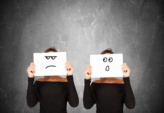 two women hiding behind sheets of paper Wall Mural