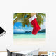 Christmas sock on palm tree at exotic tropical beach Wall Mural