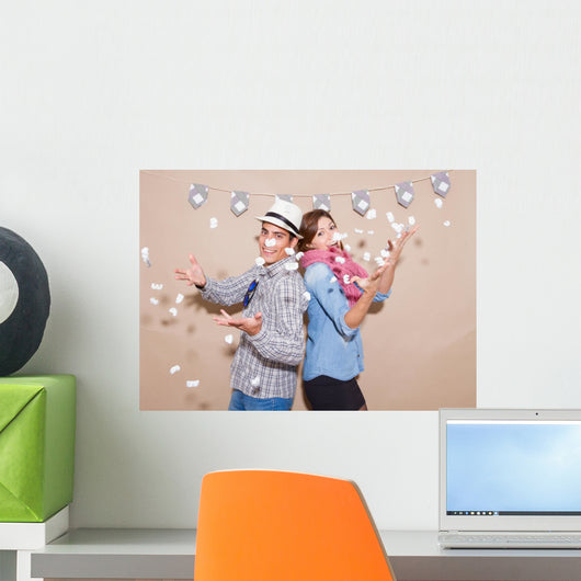 Young couple in a Photo Booth party with gesture face Wall Mural