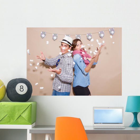 Young couple in a Photo Booth party with gesture face Wall Mural