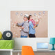 Young couple in a Photo Booth party with gesture face Wall Mural