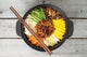 Korean cuisine, beef  Bibimbap in  a clay pot on wooden table Wall Mural