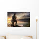 Young man fishing at misty sunrise Wall Mural