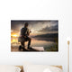 Young man fishing at misty sunrise Wall Mural