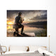 Young man fishing at misty sunrise Wall Mural