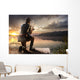 Young man fishing at misty sunrise Wall Mural