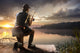 Young man fishing at misty sunrise Wall Mural