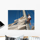 young man working on mast of sailing ship Wall Mural