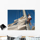 young man working on mast of sailing ship Wall Mural