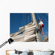 young man working on mast of sailing ship Wall Mural