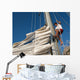 young man working on mast of sailing ship Wall Mural