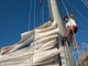 young man working on mast of sailing ship Wall Mural
