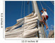 young man working on mast of sailing ship Wall Mural