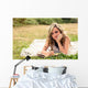 Romantic girl writing in a diary lying down outdoors Wall Mural