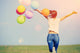 young asian woman on green grassland with colored balloons  Wall Decal