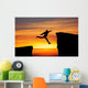 Man jumping across the gap from one rock to cling to the other. Wall Decal