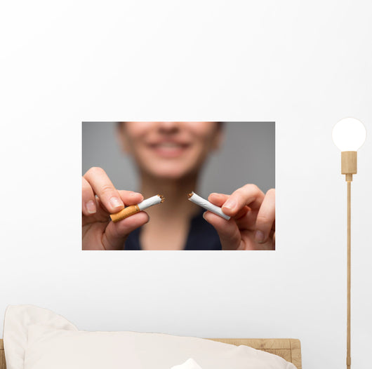 Addiction. Closeup of young attractive woman breaking cigarettes Wall Decal