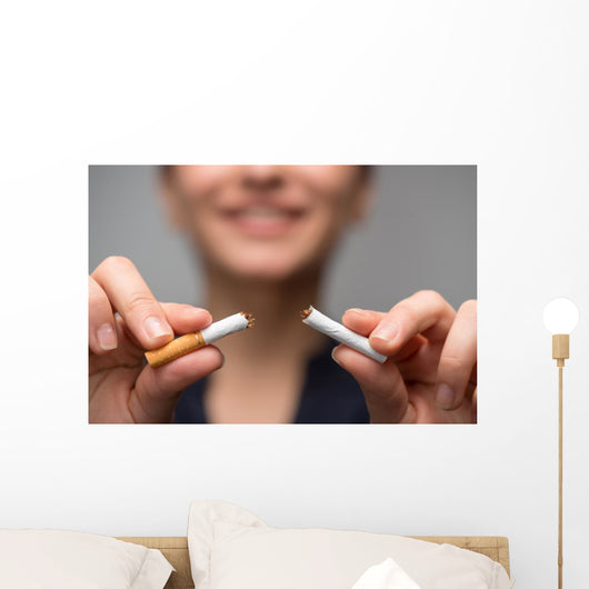 Addiction. Closeup of young attractive woman breaking cigarettes Wall Decal