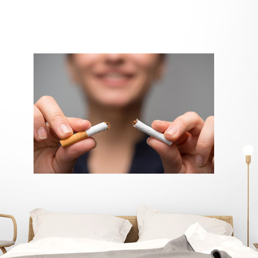 Addiction. Closeup of young attractive woman breaking cigarettes Wall Decal