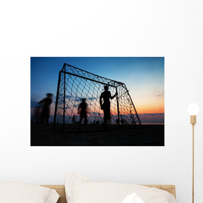 Boys Playing Football On The Beach In Summer Wall Decal shown on a wall