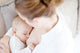 Young mother breastfeeding the newborm baby - indoors Wall Decal