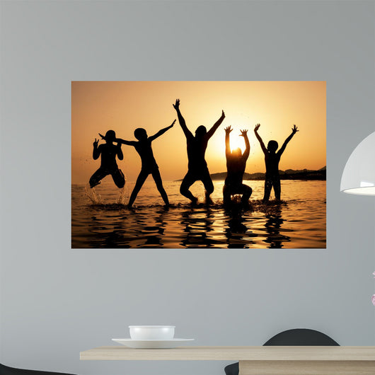 Silhouette of kids jumping on the beach Wall Decal