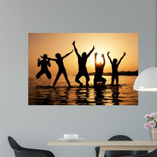 Silhouette of kids jumping on the beach Wall Decal