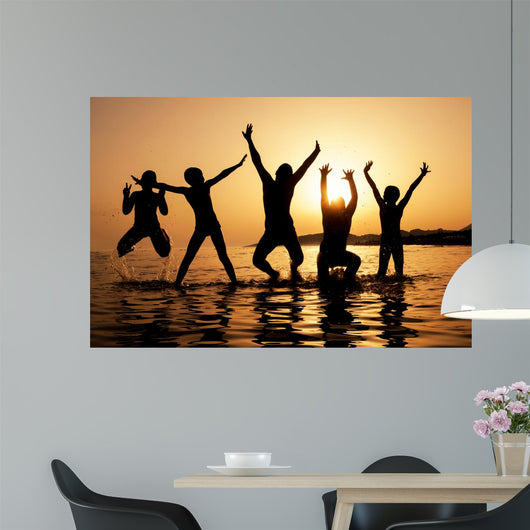 Silhouette of kids jumping on the beach Wall Decal