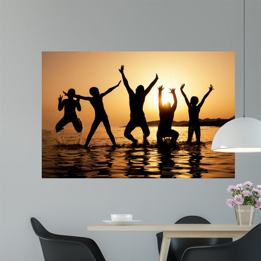 Silhouette of kids jumping on the beach Wall Decal