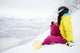 snowboarder woman sitting on snow mountain slope Wall Decal