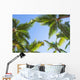 Looking up on coconut palm trees over blue sky background Wall Decal