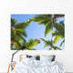 Looking up on coconut palm trees over blue sky background Wall Decal