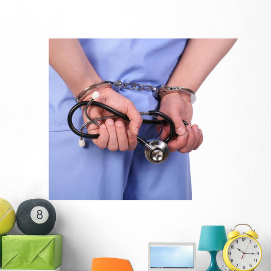 Doctor with stethoscope in handcuffs isolated on white Wall Decal
