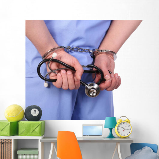 Doctor with stethoscope in handcuffs isolated on white Wall Decal