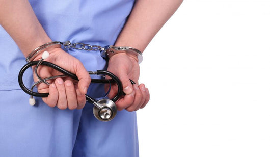 Doctor with stethoscope in handcuffs isolated on white Wall Decal