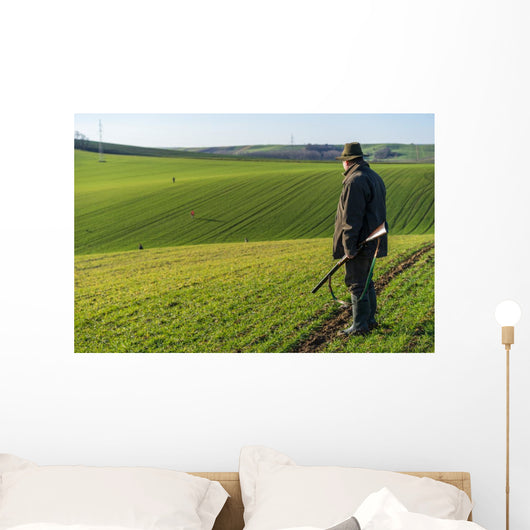 Gamekeeper walks over field. Wall Decal