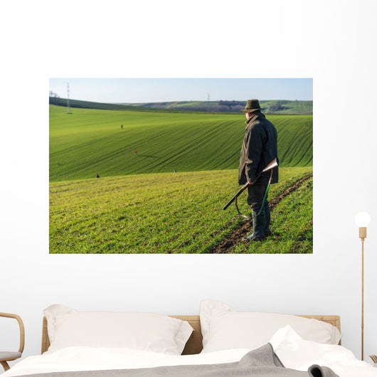Gamekeeper walks over field. Wall Decal