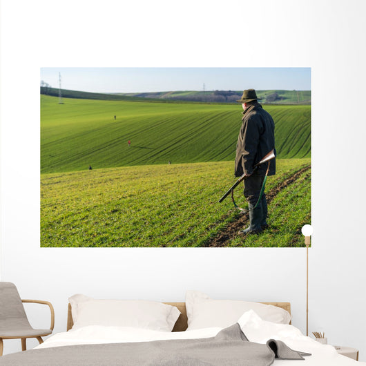Gamekeeper walks over field. Wall Decal