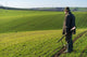 Gamekeeper walks over field. Wall Decal