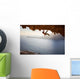Rock climber climbing along roof in cave at sunset Wall Decal