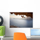 Rock climber climbing along roof in cave at sunset Wall Decal