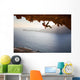 Rock climber climbing along roof in cave at sunset Wall Decal