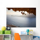 Rock climber climbing along roof in cave at sunset Wall Decal
